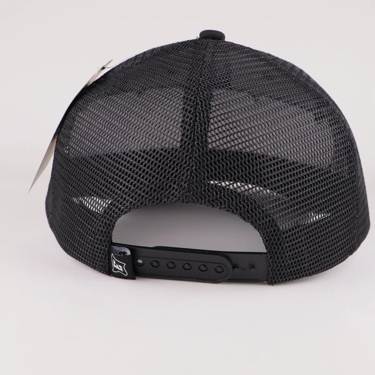 Rear black mesh panels and adjustable plastic snapback closure of patch trucker cap