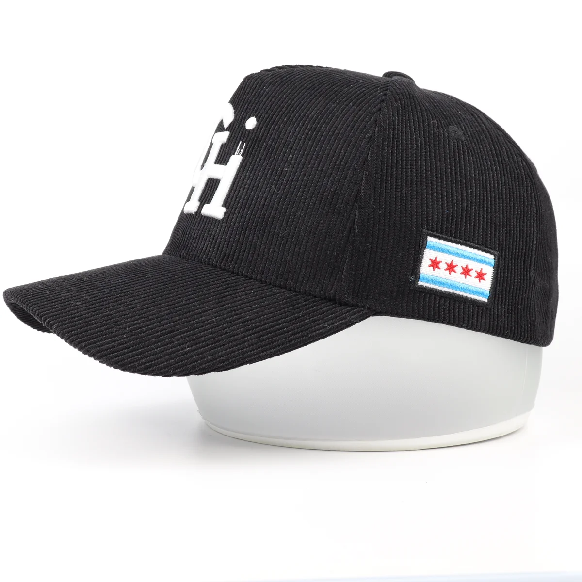 Close view of side embroidery patch and raised white lettering on black corduroy cap