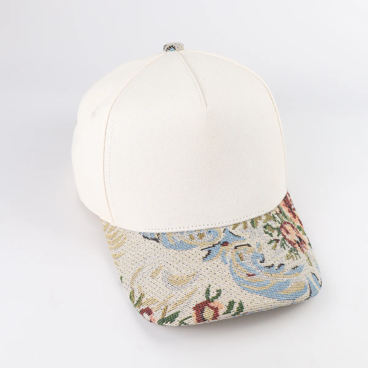 Front angle of cream cap with floral patterned woven-look visor